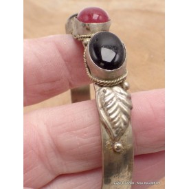 Bracelet métal jaune avec pierres noires et motif feuille.