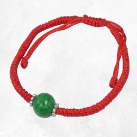 Bracelet tibétain porte-bonheur fil rouge et jade vert béni au Népal