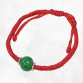 Bracelet tibétain porte-bonheur fil rouge et jade vert béni au Népal