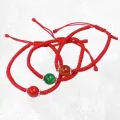 Bracelet tibétain porte-bonheur fil rouge et jade vert béni au Népal