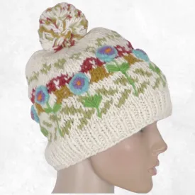 Bonnet femme en laine écru à pompon, fleurs turquoise et violettes brodées en relief