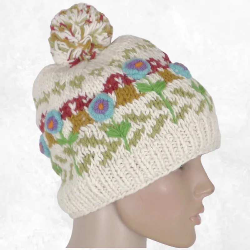 Bonnet femme en laine écru à pompon, fleurs turquoise et violettes brodées en relief