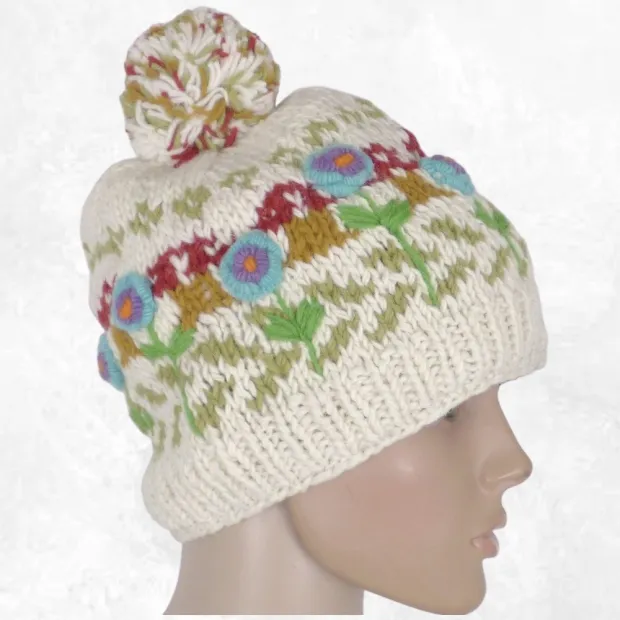 Bonnet femme en laine écru à pompon, fleurs turquoise et violettes brodées en relief