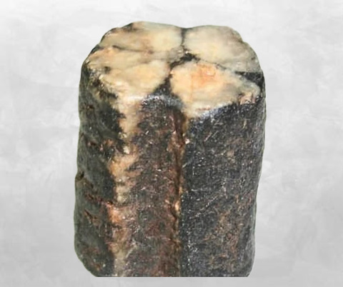Bloc brut de chiastolite avant polissage, croix visible en coupe